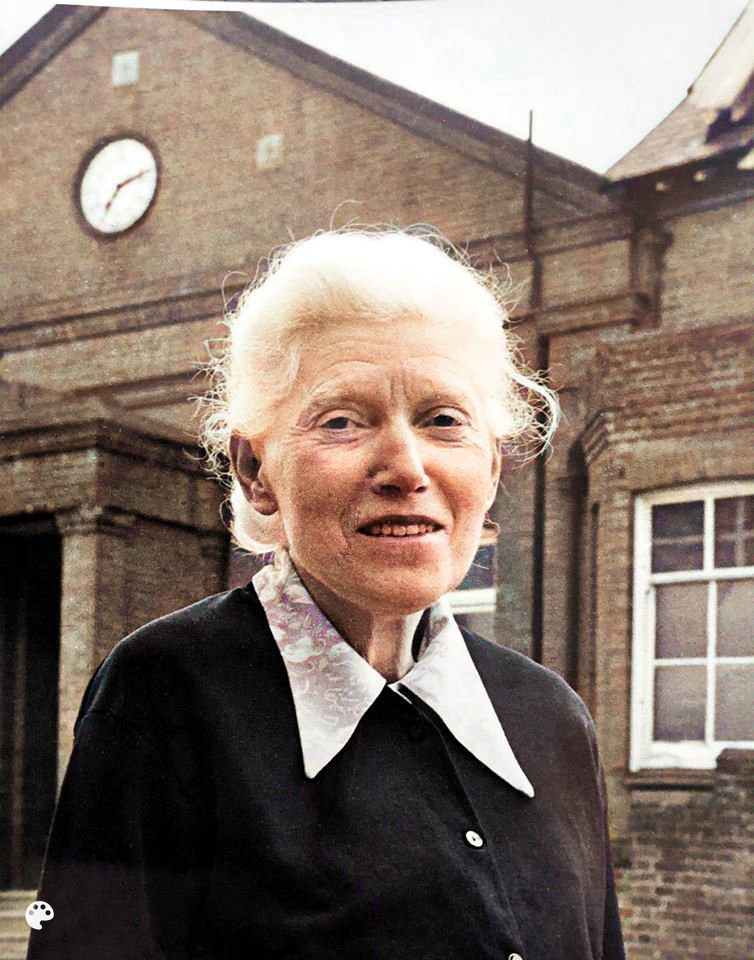 Lucie Bishop (1909 - 1984), founding force of Henfield Museum, outside the old Henfield Assembly Rooms, mid 1970s. Photo colourised, 2020. Image: Henfield Museum